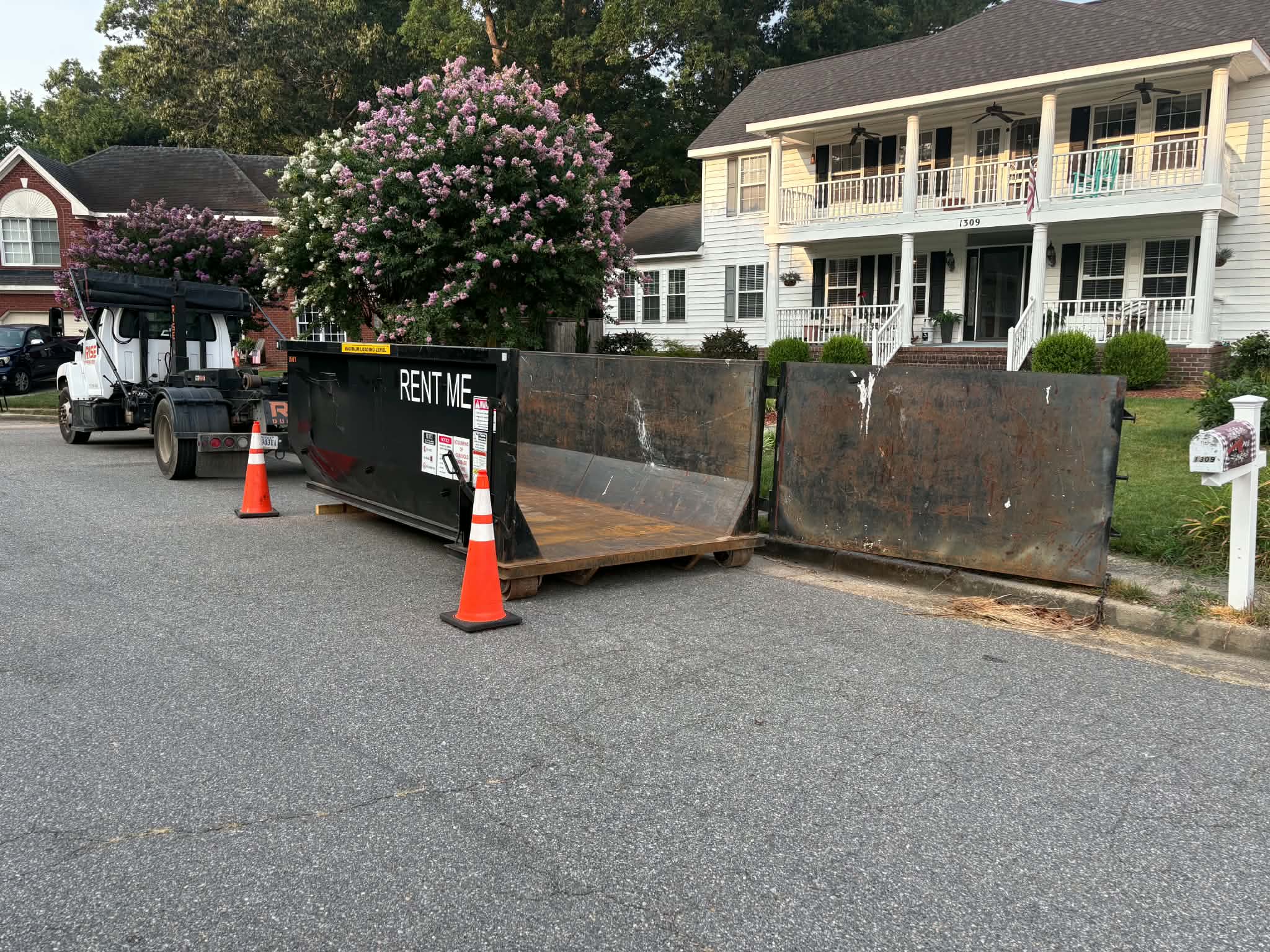 RISE Dumpsters 10-yard roll-off dumpster rental on a Norfolk, VA driveway with wood board driveway protection.