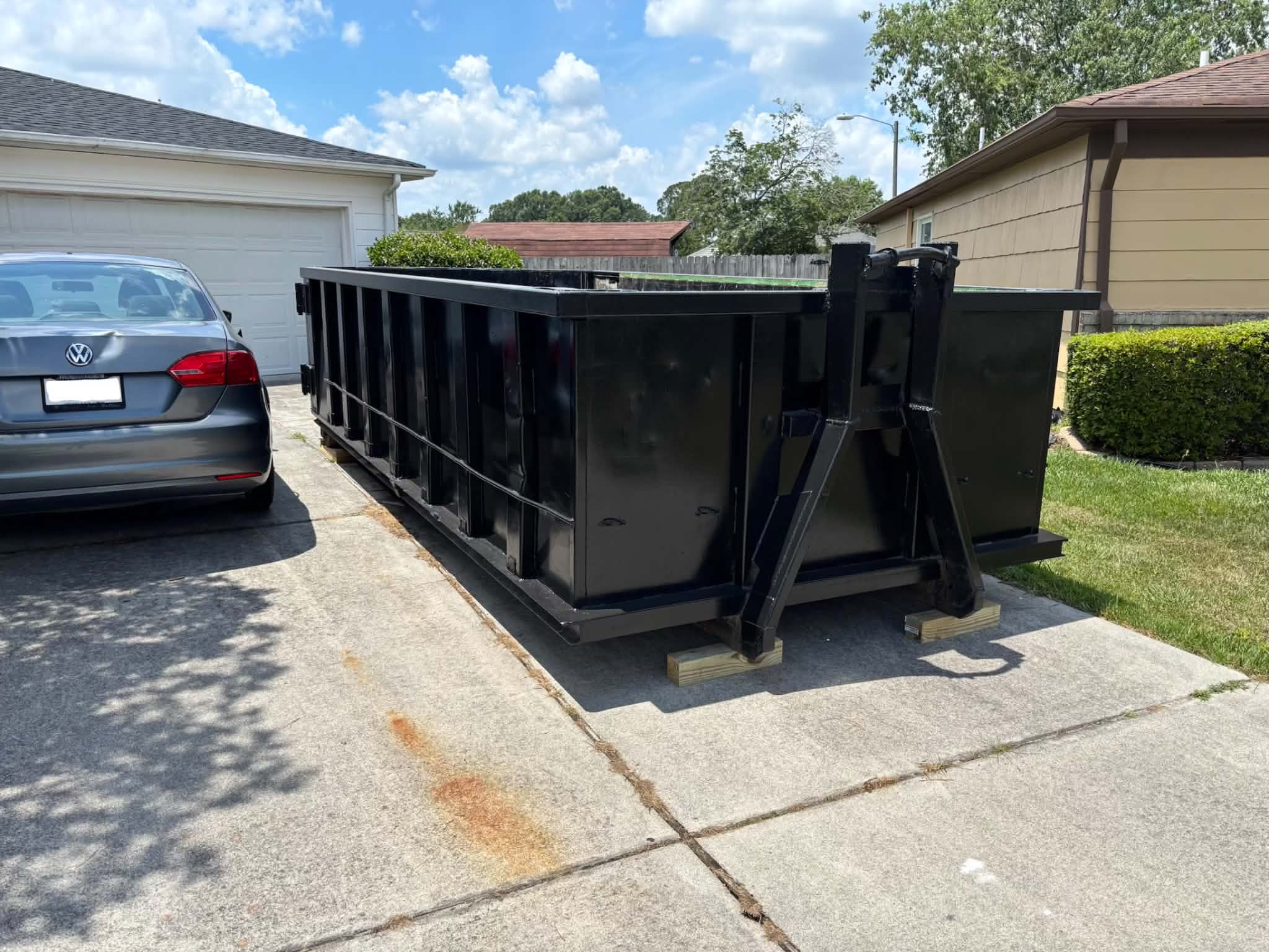 RISE Dumpsters 15-yard roll-off dumpster rental loaded with debris at a Norfolk, VA job site.